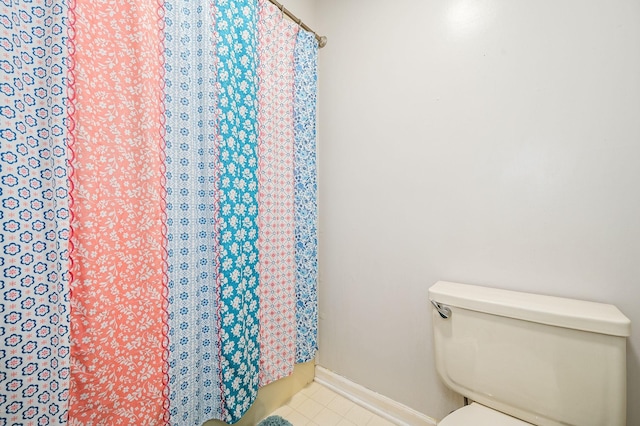 full bathroom with baseboards, tile patterned flooring, toilet, and a shower with curtain