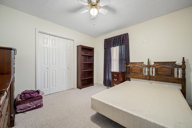bedroom featuring a closet, baseboards, ceiling fan, a textured ceiling, and carpet