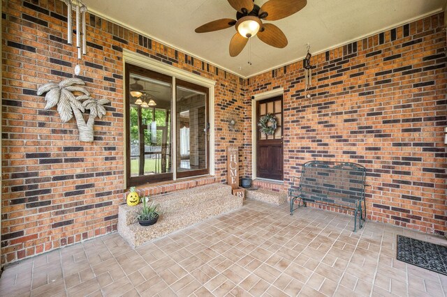 doorway to property with brick siding and ceiling fan