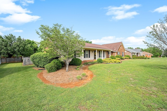 exterior space with fence, a front lawn, and brick siding