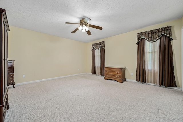 unfurnished bedroom with carpet flooring, a textured ceiling, ceiling fan, and baseboards