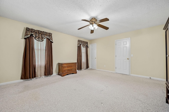 unfurnished bedroom with baseboards, light carpet, and a textured ceiling