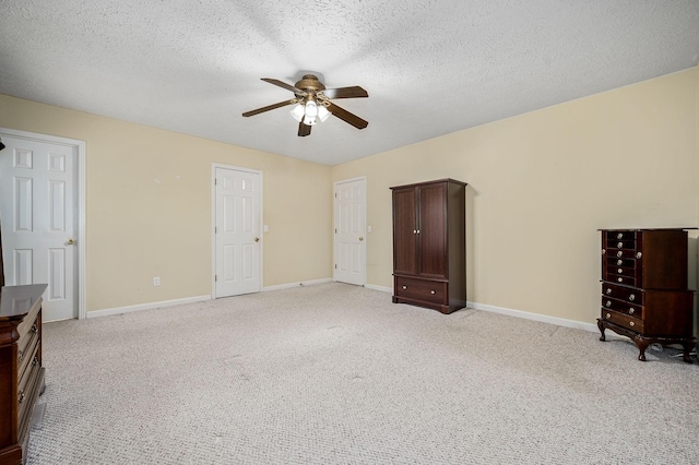 unfurnished bedroom with baseboards, light carpet, a ceiling fan, and a textured ceiling