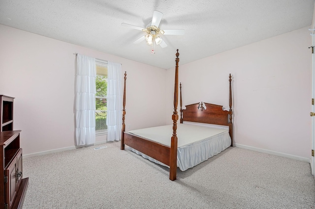 carpeted bedroom featuring baseboards, a ceiling fan, a textured ceiling, and visible vents