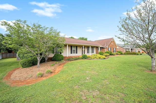 ranch-style house featuring brick siding, fence, and a front yard