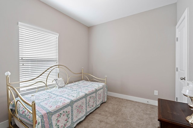 bedroom featuring baseboards and light colored carpet