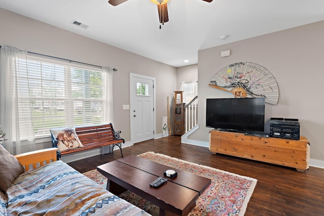 living room with stairway, ceiling fan, wood finished floors, and visible vents