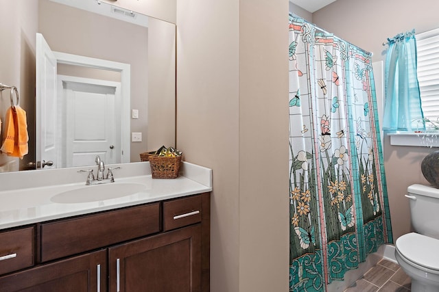 bathroom featuring visible vents, a shower with curtain, toilet, and vanity
