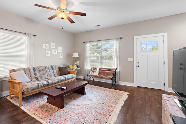 living room featuring a ceiling fan, baseboards, visible vents, and wood finished floors