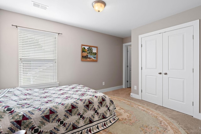 bedroom with light colored carpet, baseboards, visible vents, and a closet