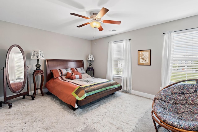 carpeted bedroom featuring baseboards, ceiling fan, visible vents, and multiple windows