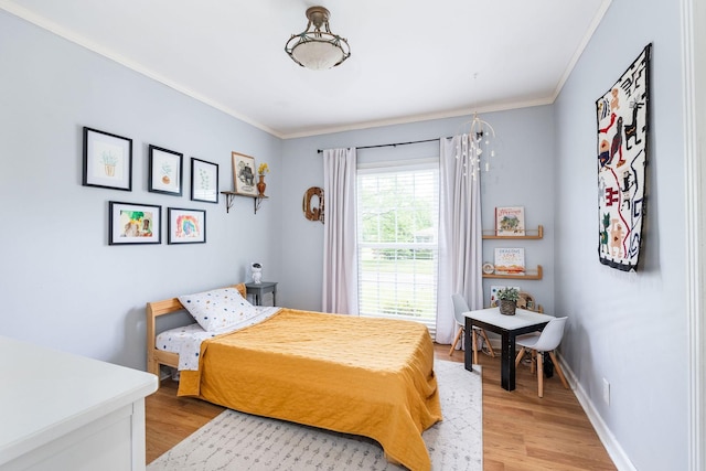 bedroom with baseboards, ornamental molding, and light wood-type flooring