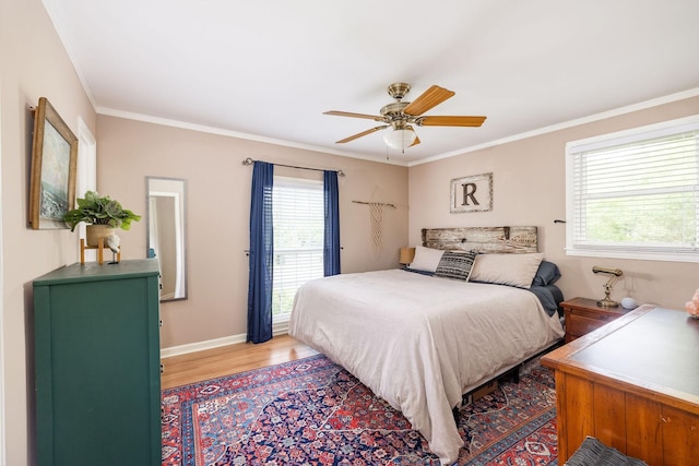 bedroom with baseboards, ornamental molding, a ceiling fan, and wood finished floors