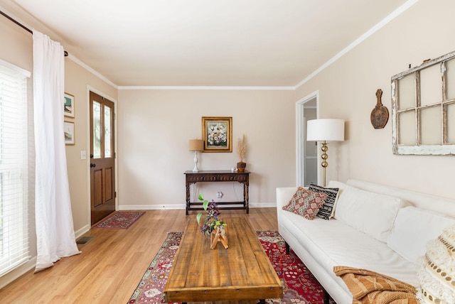 living room featuring baseboards, ornamental molding, and light wood-type flooring