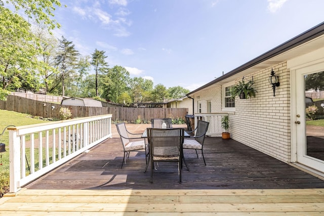 deck featuring a fenced backyard and outdoor dining space