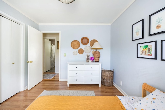 bedroom featuring baseboards, ornamental molding, and wood finished floors