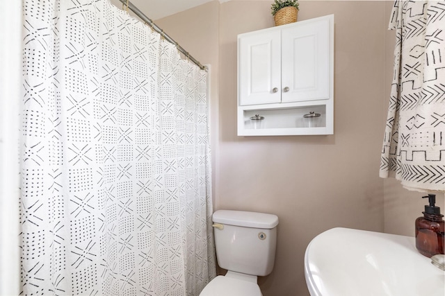 bathroom with toilet and curtained shower