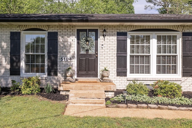 doorway to property with brick siding