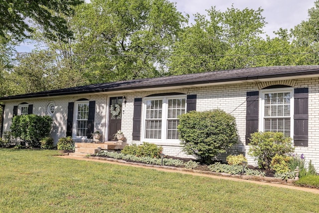 ranch-style home with brick siding and a front yard