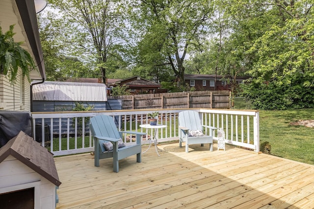 wooden terrace featuring a lawn and fence
