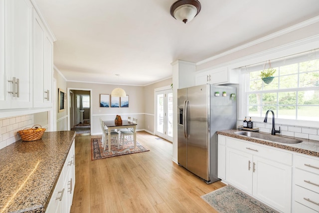 kitchen featuring crown molding, a sink, stainless steel fridge with ice dispenser, and light wood-type flooring