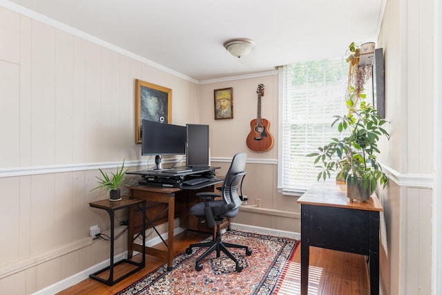 office featuring ornamental molding, a decorative wall, and wood finished floors