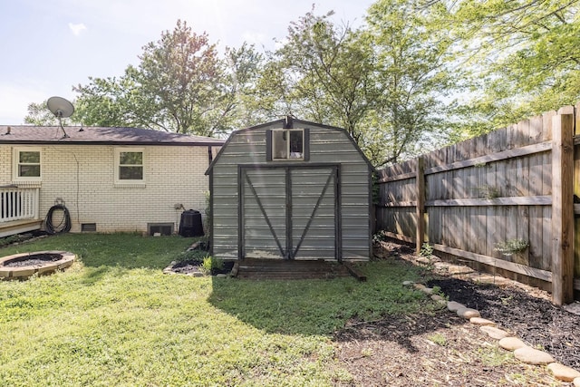view of shed featuring fence and a fire pit