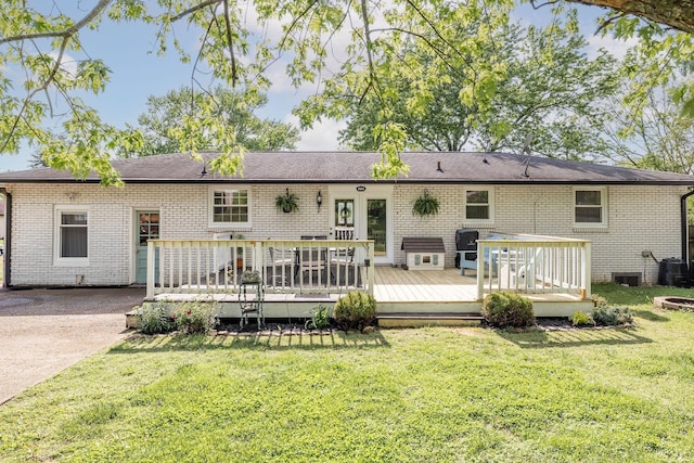 back of house with a lawn, a deck, and brick siding