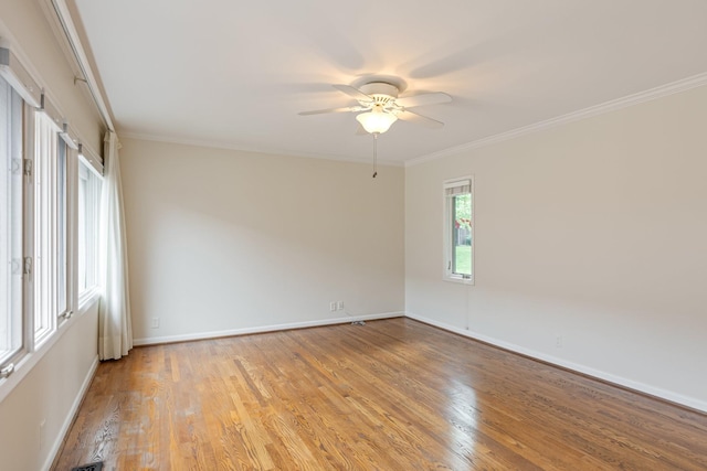 spare room featuring baseboards, ceiling fan, ornamental molding, and light wood-type flooring