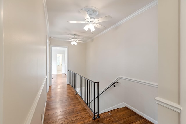 hall with crown molding, wood finished floors, and an upstairs landing