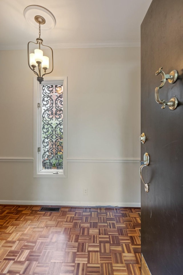 interior space featuring crown molding, baseboards, and visible vents