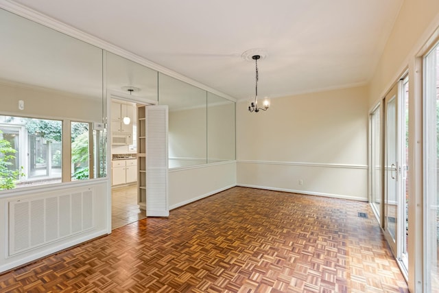 unfurnished room with visible vents, ornamental molding, baseboards, and a chandelier