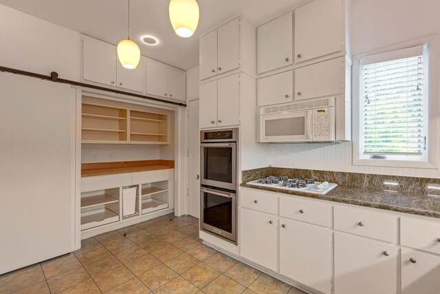 kitchen with light tile patterned floors, pendant lighting, white appliances, and white cabinetry