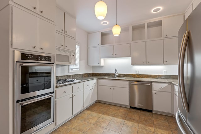 kitchen featuring a sink, white cabinets, decorative light fixtures, and stainless steel appliances