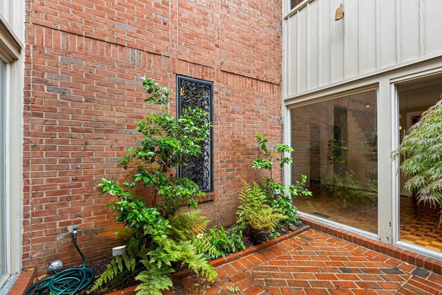 view of exterior entry with brick siding