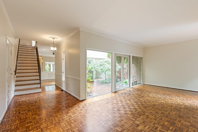 empty room featuring baseboards, ornamental molding, stairs, and a chandelier