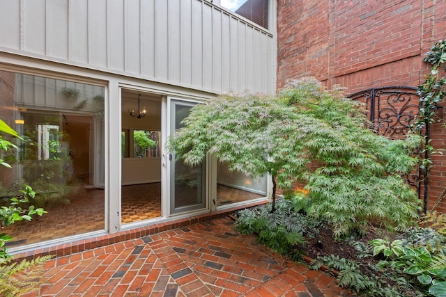 doorway to property with board and batten siding and brick siding