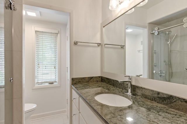 full bath featuring vanity, baseboards, walk in shower, and toilet