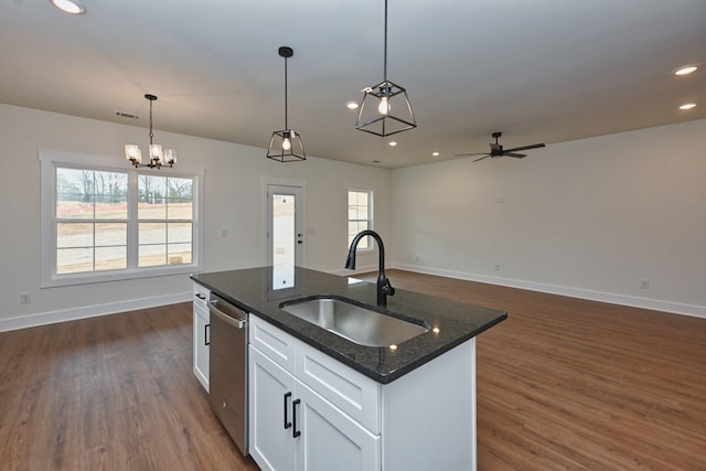 kitchen with baseboards, a sink, dishwasher, and dark wood-style floors