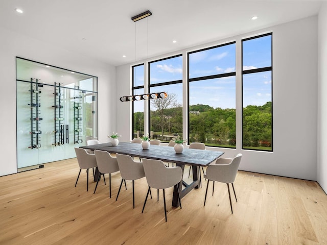 dining space featuring a wall of windows, recessed lighting, and light wood-style flooring