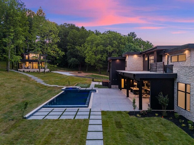 view of pool featuring a lawn and a patio