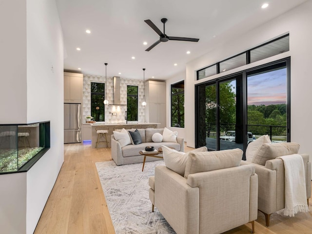 living area featuring recessed lighting, ceiling fan, and light wood-type flooring