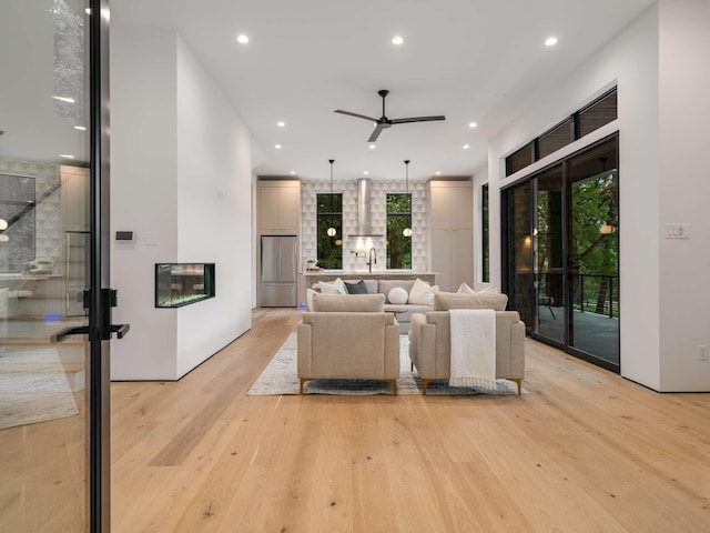 living room featuring a ceiling fan, recessed lighting, and light wood-type flooring