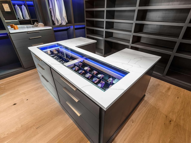 kitchen featuring light stone counters, light wood-type flooring, modern cabinets, and a center island