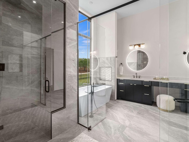 full bath featuring vanity, marble finish floor, a wealth of natural light, a soaking tub, and a stall shower