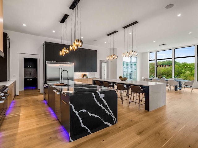 kitchen featuring dark cabinetry, modern cabinets, a notable chandelier, and a spacious island