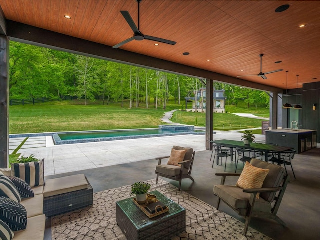 view of patio featuring outdoor dining space, a sink, a pool with connected hot tub, outdoor lounge area, and a ceiling fan