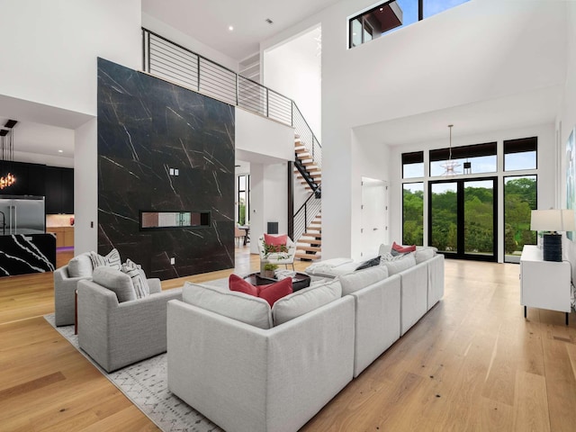 living area featuring stairway, a high ceiling, and wood finished floors