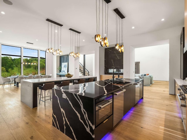 kitchen with an inviting chandelier, light wood finished floors, recessed lighting, a large island, and modern cabinets