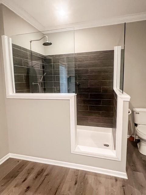 bathroom with crown molding, walk in shower, toilet, baseboards, and wood finished floors